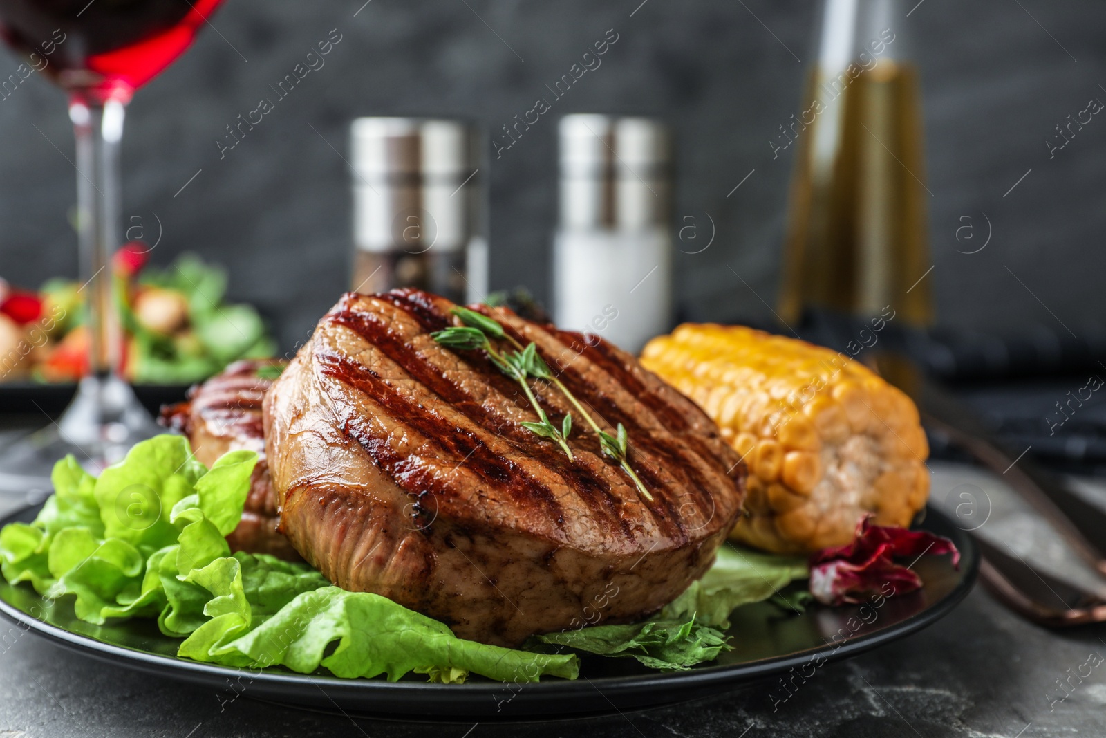 Photo of Delicious beef medallions served on grey table, closeup