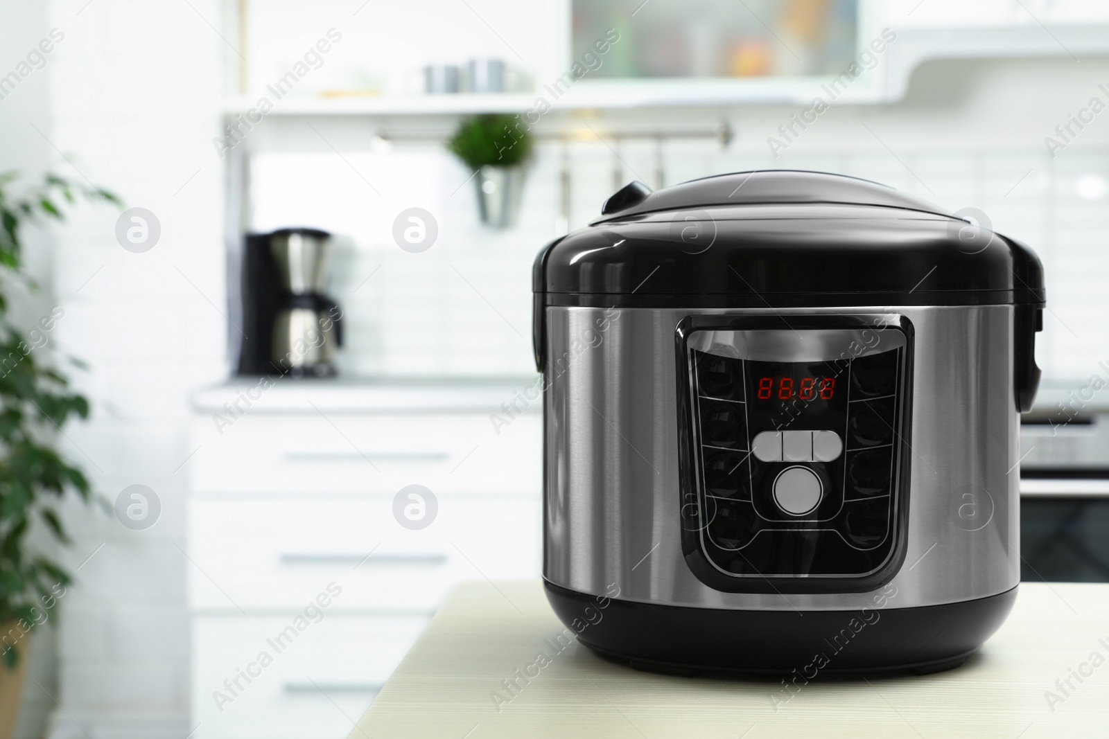 Photo of Modern multi cooker on table in kitchen. Space for text