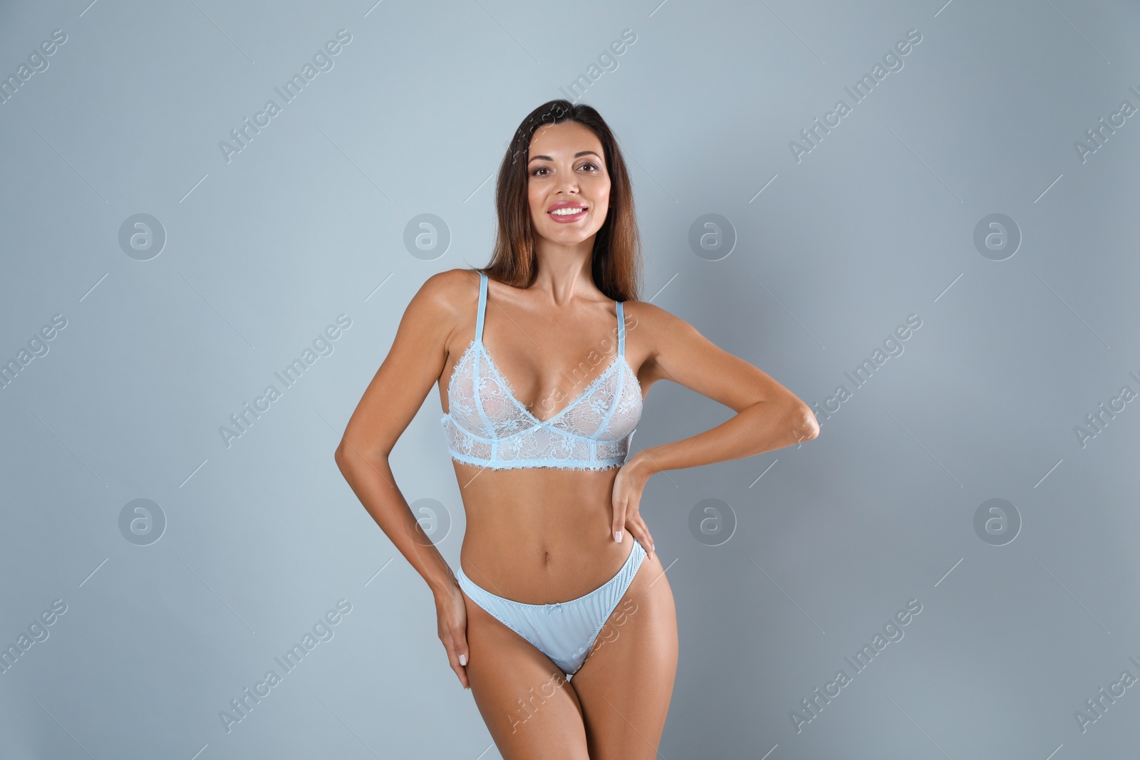 Photo of Beautiful woman in sexy panties and bra on light grey background