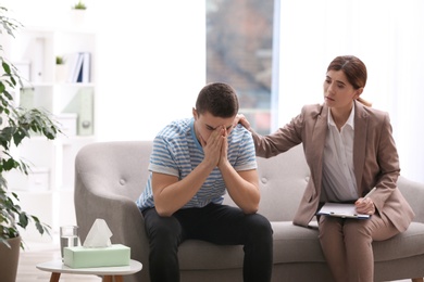 Photo of Psychotherapist working with young man in office