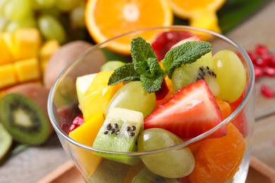 Photo of Delicious fresh fruit salad in dish on table, closeup view