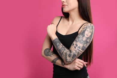 Photo of Woman with tattoos on arms against pink background, closeup. Space for text