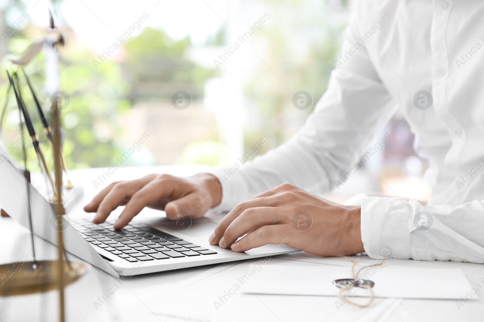 Photo of Male notary working with laptop at table in office, closeup