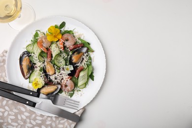 Photo of Plate of delicious salad with seafood on white table, flat lay