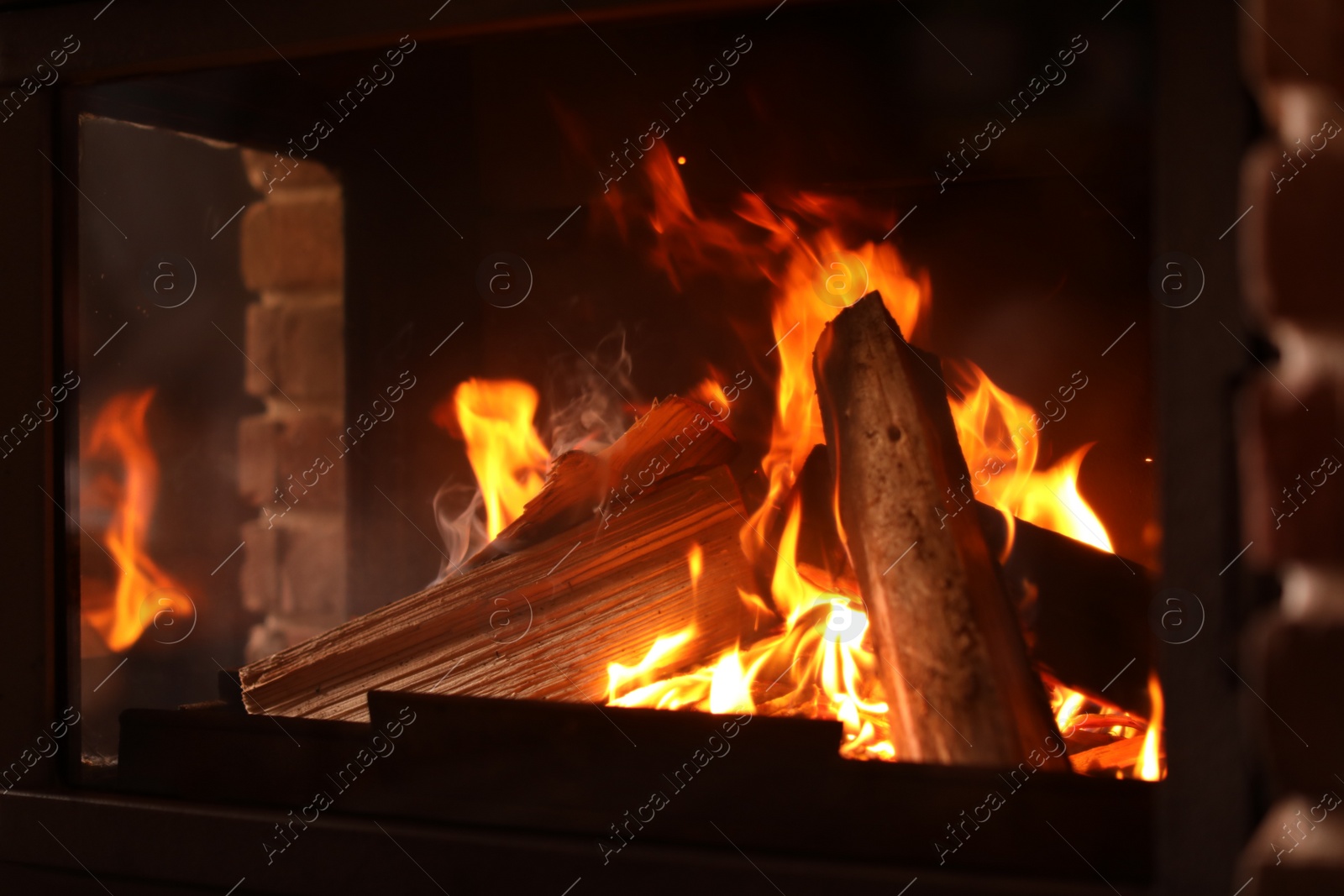 Photo of Fireplace with burning wood, closeup view. Winter vacation