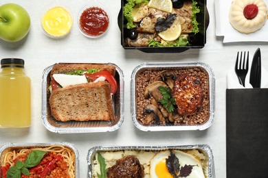 Photo of Lunchboxes on white wooden table, flat lay. Healthy food delivery