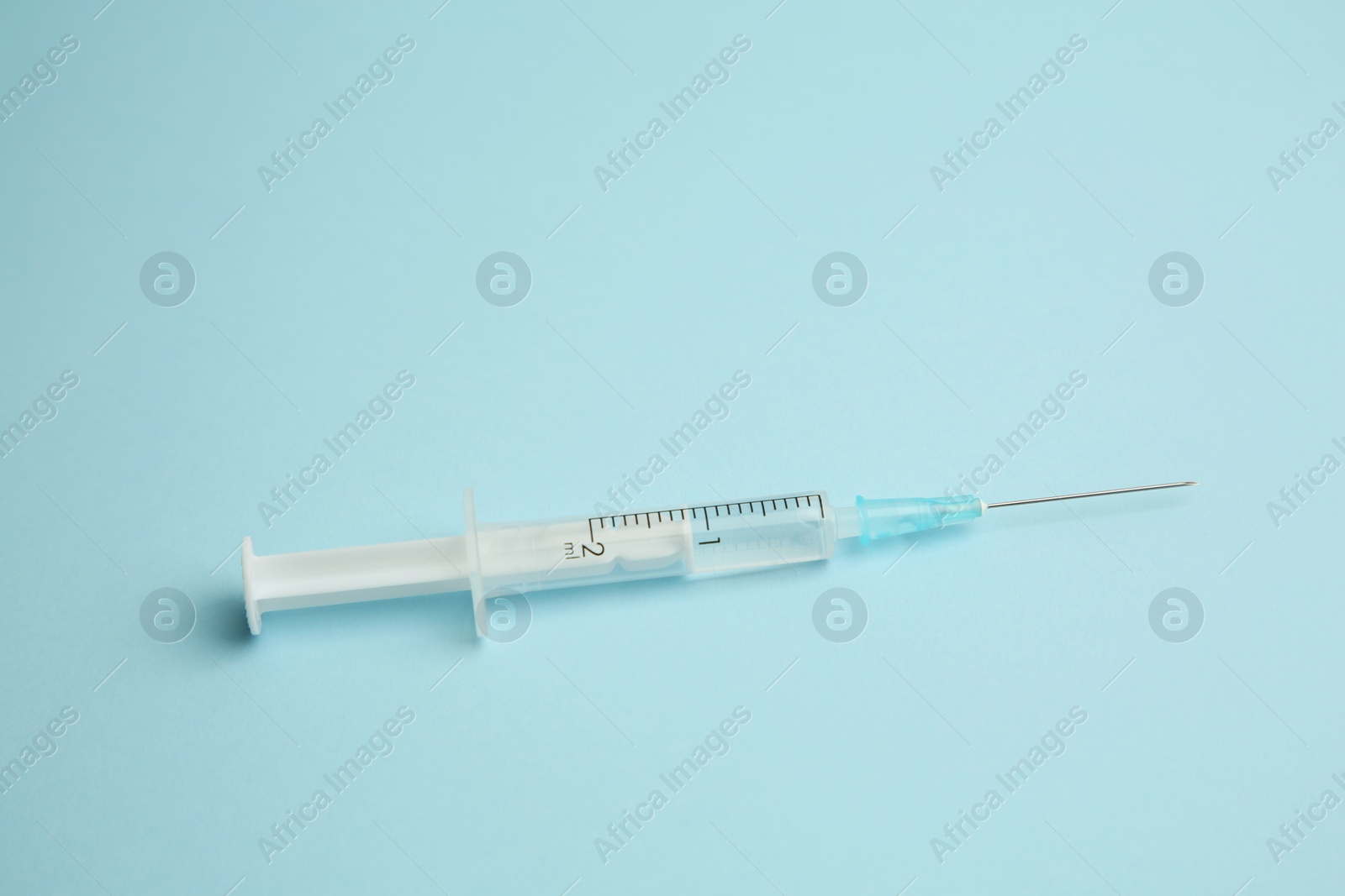 Photo of One medical syringe on light blue background