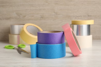 Photo of Many different rolls of adhesive tape on wooden table