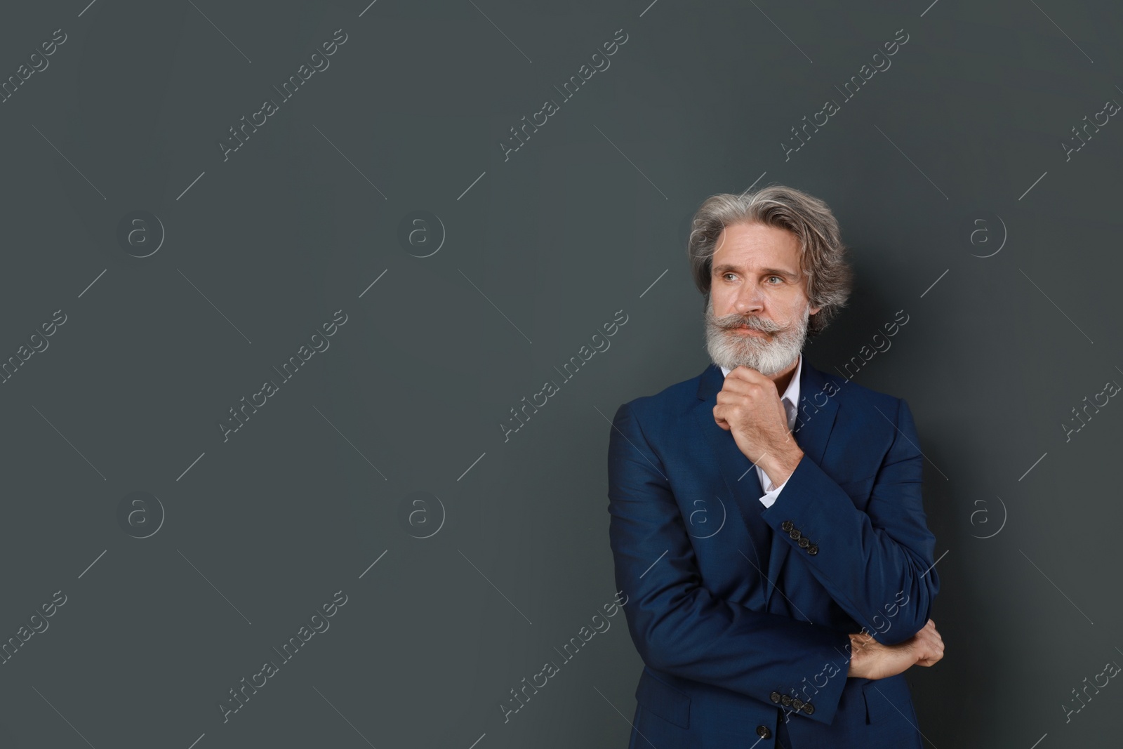 Photo of Portrait of handsome mature man on dark background. Space for text