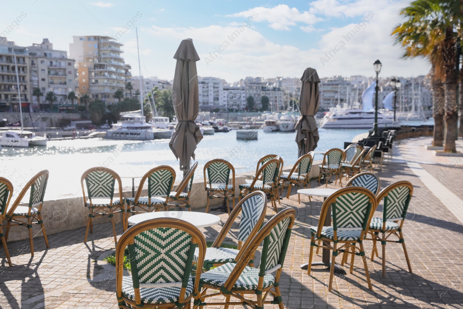 Photo of Beautiful view of modern cafe with outdoor terrace near port