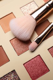 Photo of Beautiful eye shadow palette and brushes as background, closeup