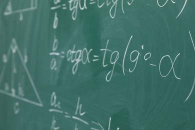 Photo of Many different math formulas written on chalkboard