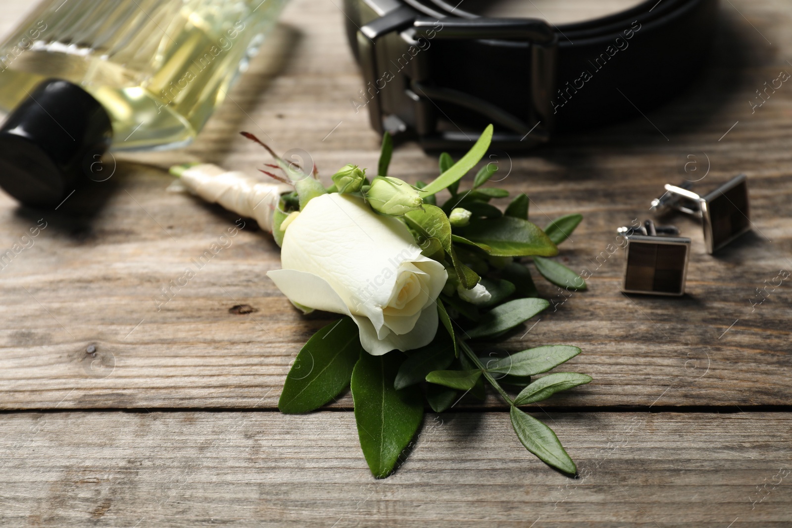Photo of Wedding stuff. Composition with stylish boutonniere on wooden table, closeup