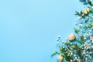 Beautiful floral composition with gypsophila and roses on light blue background, flat lay. Space for text