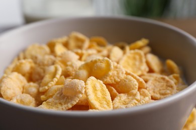Photo of Tasty cornflakes with milk in bowl, closeup