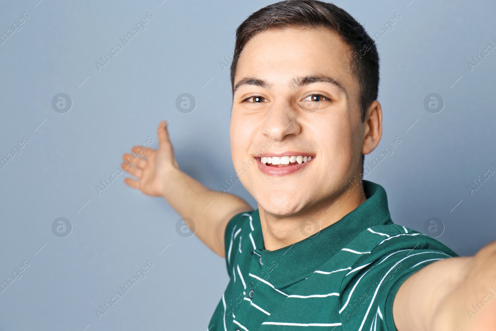 Photo of Young handsome man taking selfie against grey background
