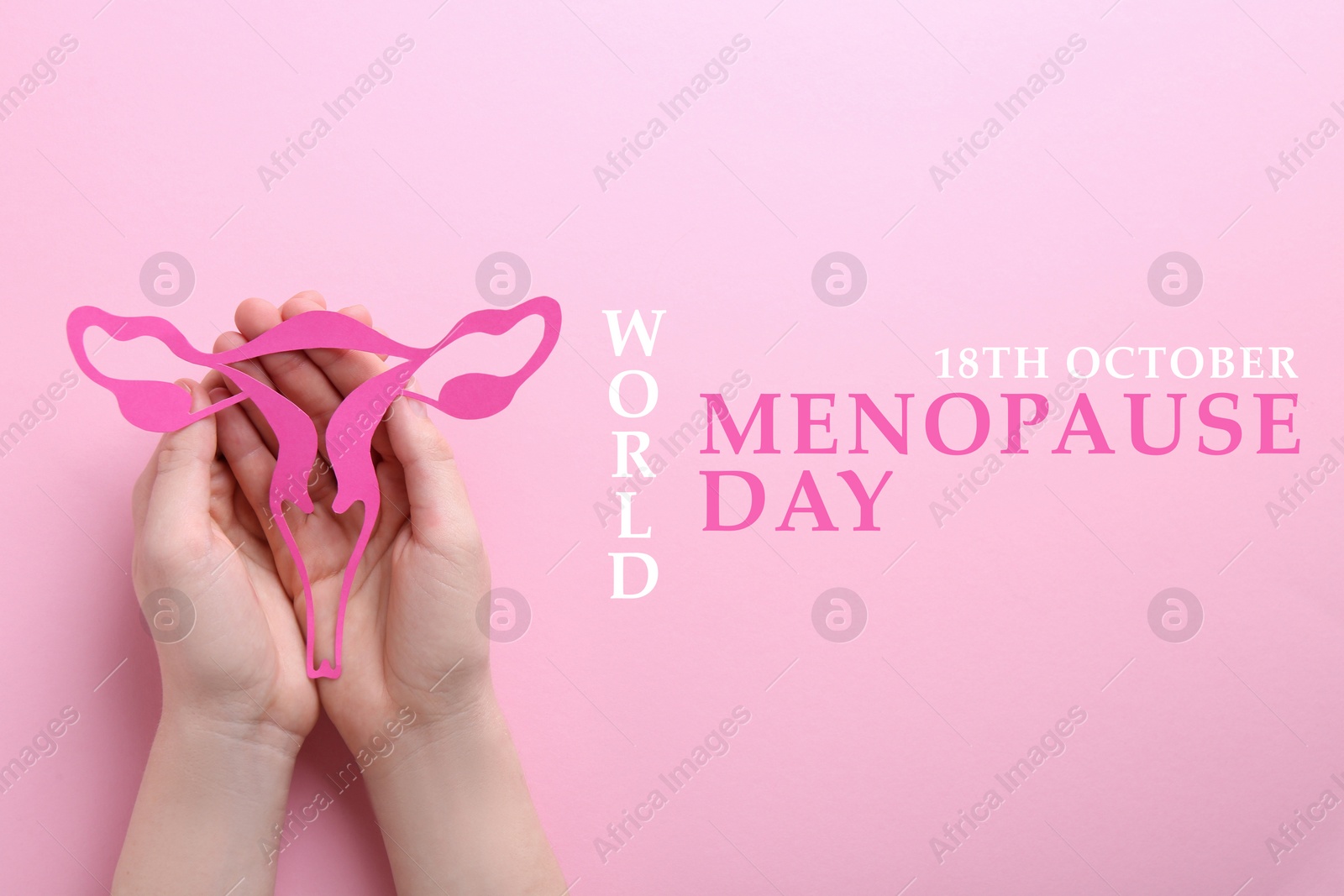 Image of World Menopause Day - October, 18. Woman holding paper uterus on pink background, top view