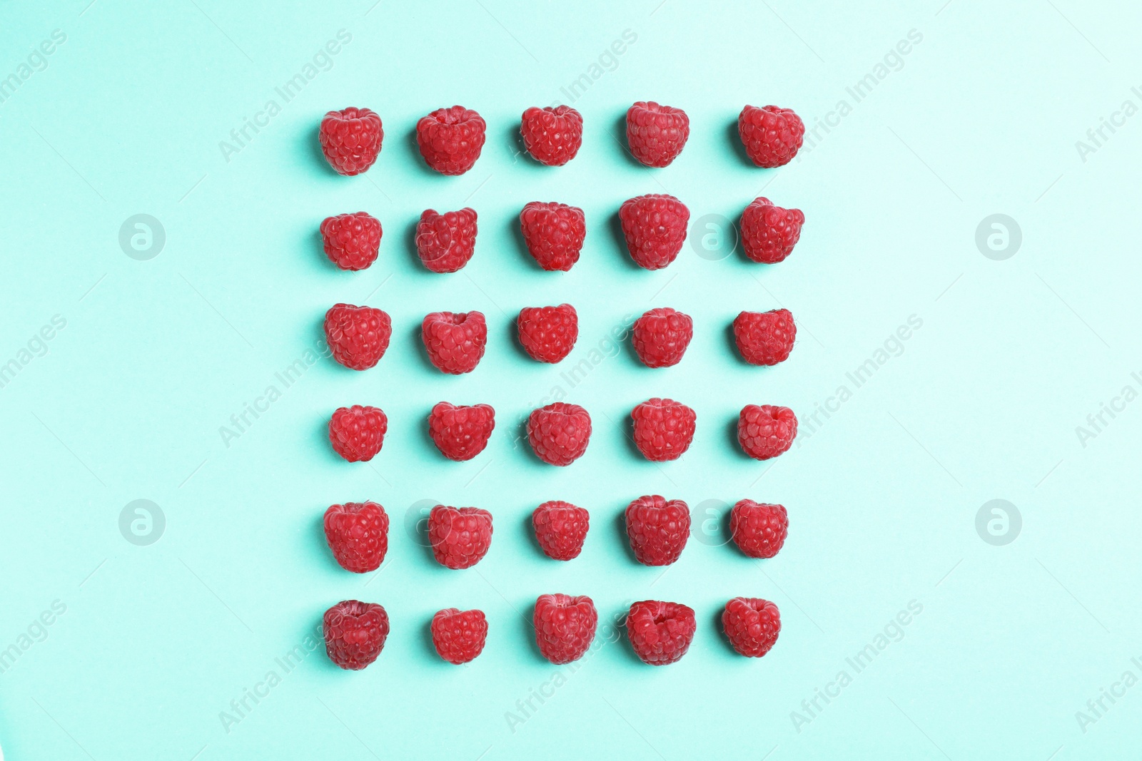 Photo of Flat lay composition with ripe aromatic raspberries on color background