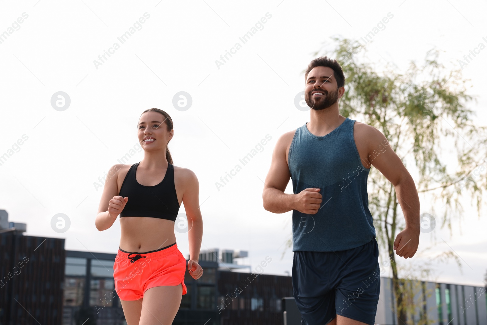 Photo of Healthy lifestyle. Happy young couple running outdoors