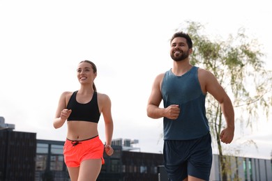 Photo of Healthy lifestyle. Happy young couple running outdoors