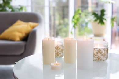 Burning candles on table indoors. Interior decor element