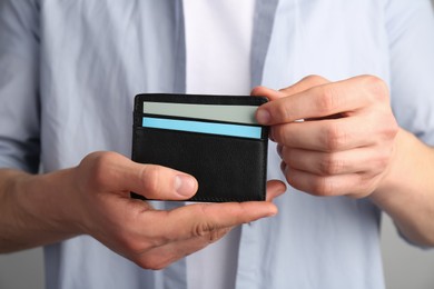 Man holding leather business card holder with cards, closeup