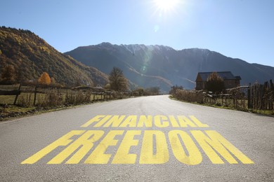 Image of Way to financial freedom. Words on asphalt road
