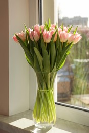 Photo of Spring is coming. Bouquet of beautiful tulip flowers in glass vase on windowsill indoors