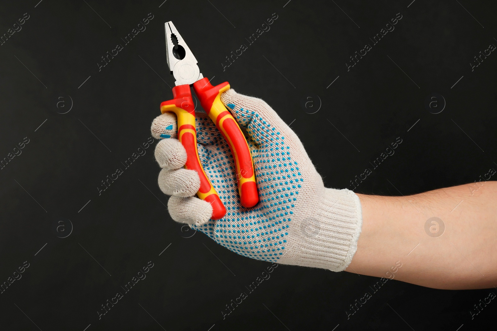 Photo of Man with combination pliers on black background, closeup