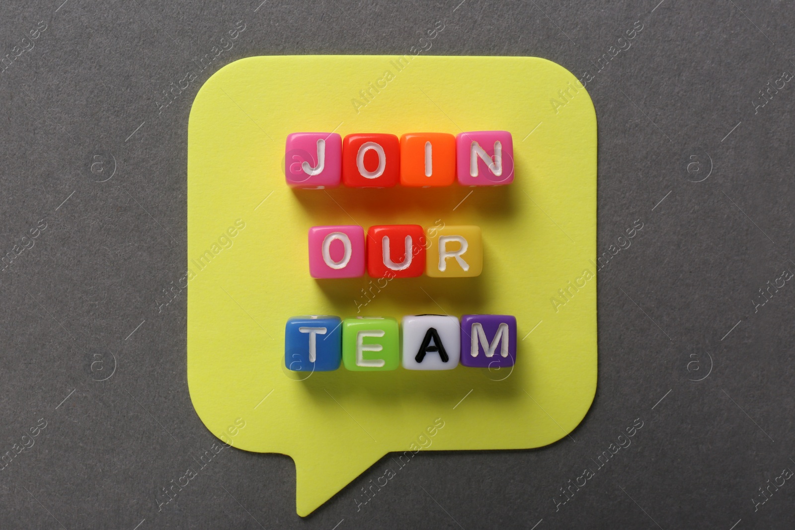 Photo of Recruitment process concept. Phrase Join Our Team made of colorful cubes on grey background, flat lay