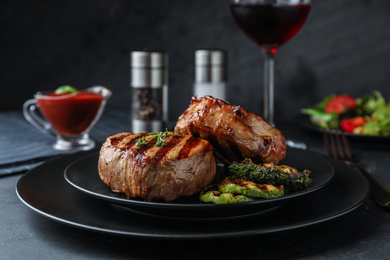 Delicious beef medallions served on black table