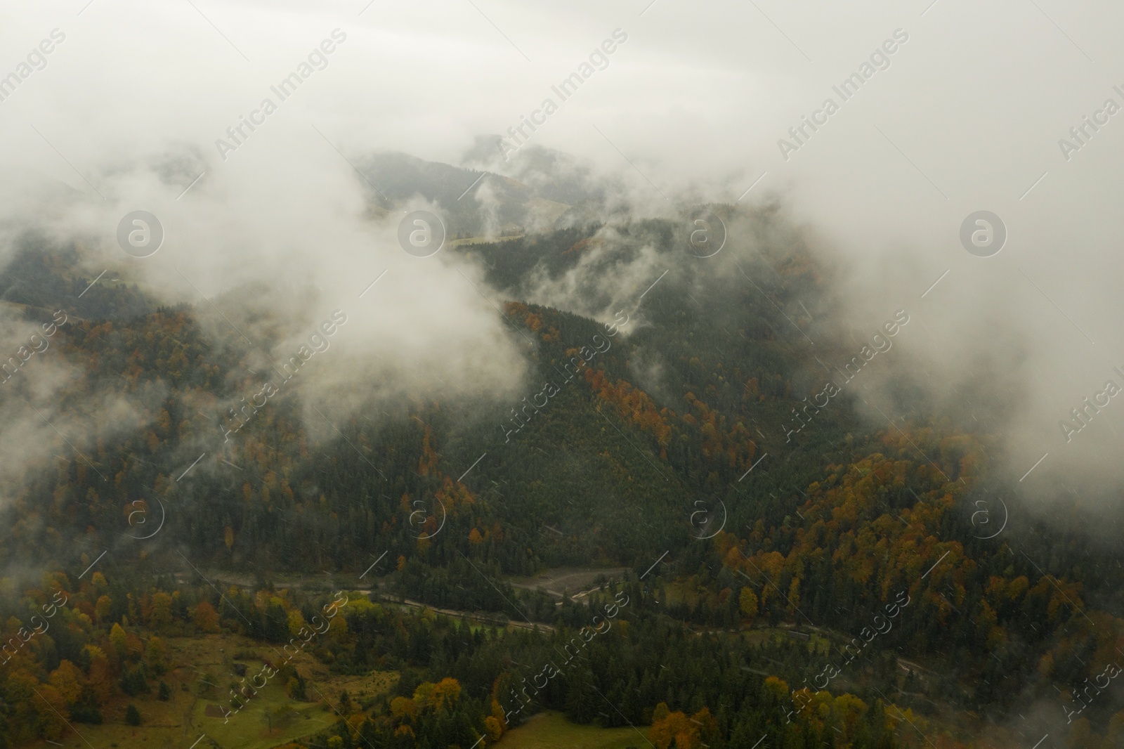 Image of Aerial view of mountains covered with fog