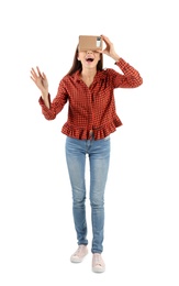 Photo of Young woman using cardboard virtual reality headset, isolated on white