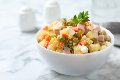 Photo of Delicious homemade salad Olivier on marble table