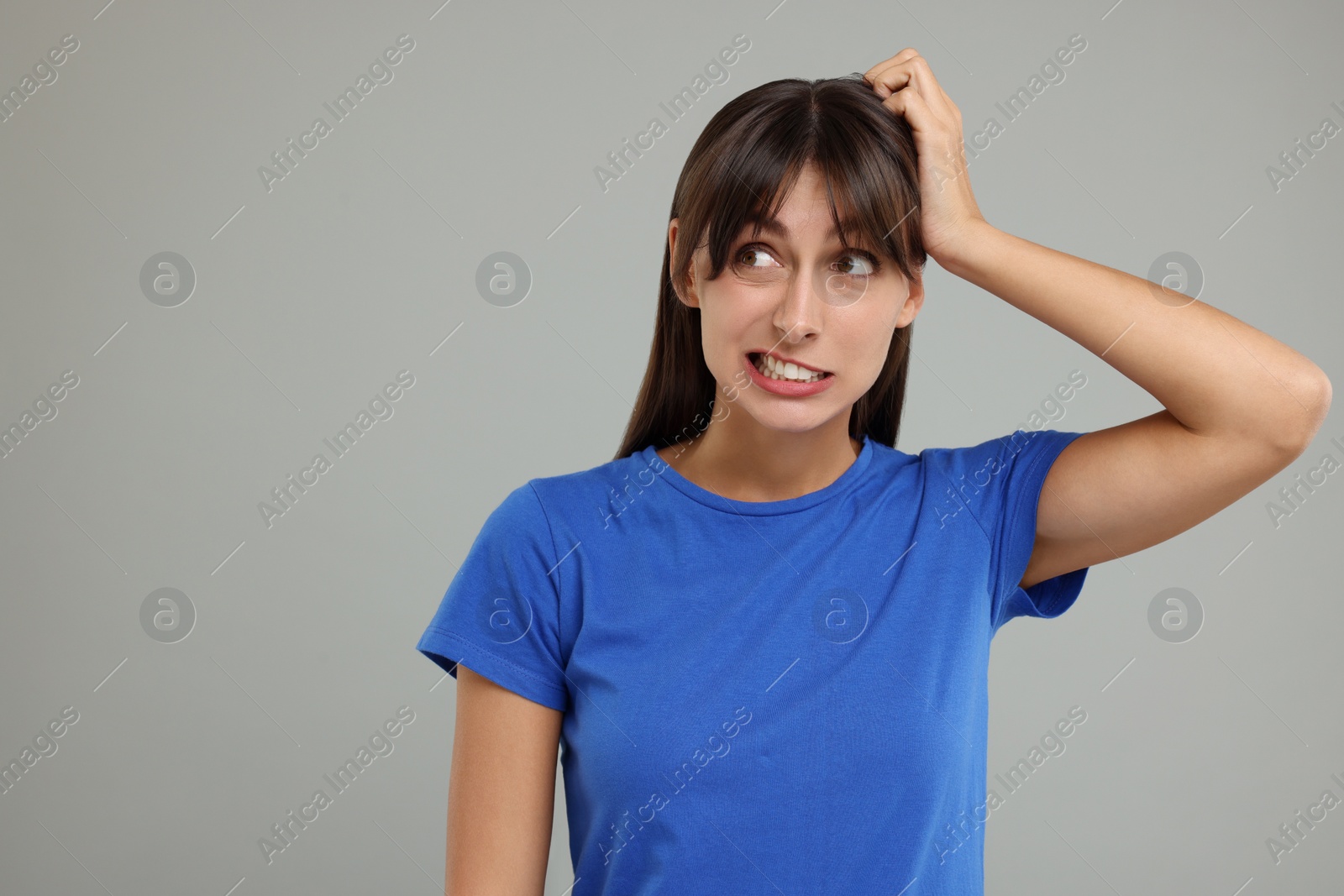 Photo of Embarrassed woman on light grey background, space for text