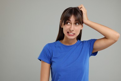 Photo of Embarrassed woman on light grey background, space for text