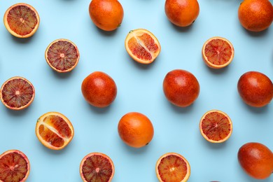 Photo of Many ripe sicilian oranges on light blue background, flat lay