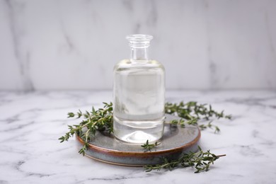 Thyme essential oil on white marble table