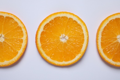 Fresh orange slices on light background, flat lay