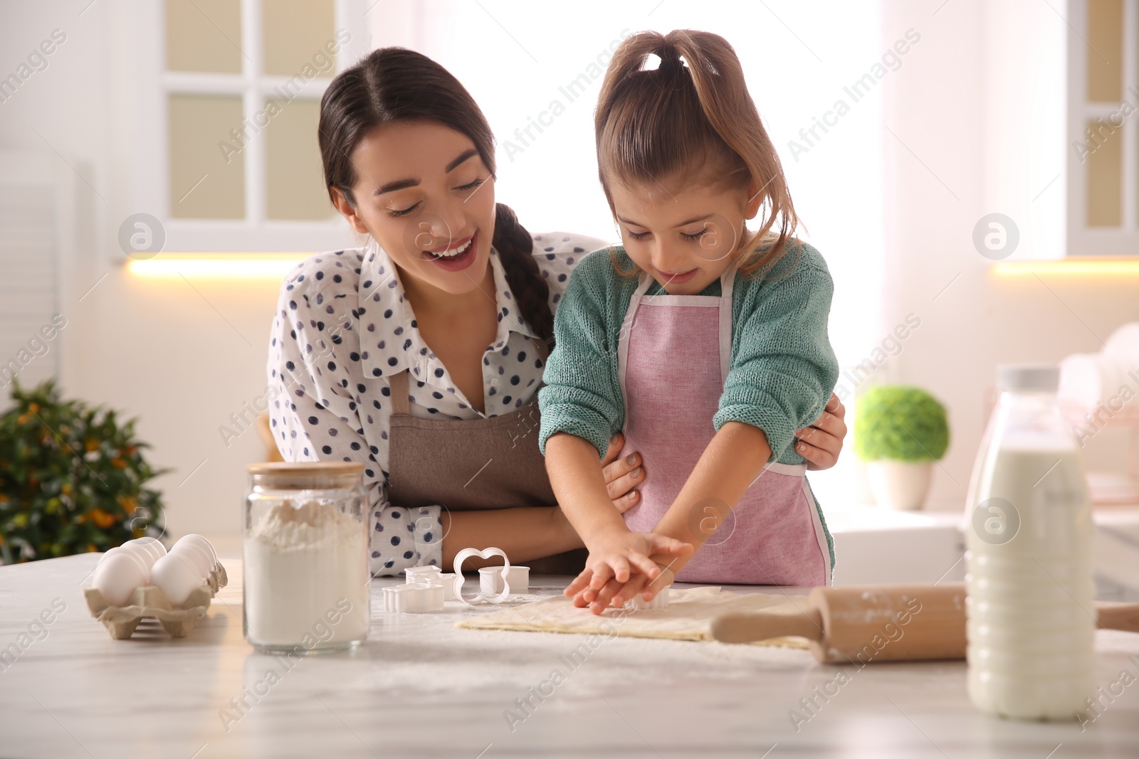 Photo of Mother and daughter making pastry in kitchen at home