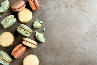 Photo of Delicious macarons on grey table, flat lay. Space for text