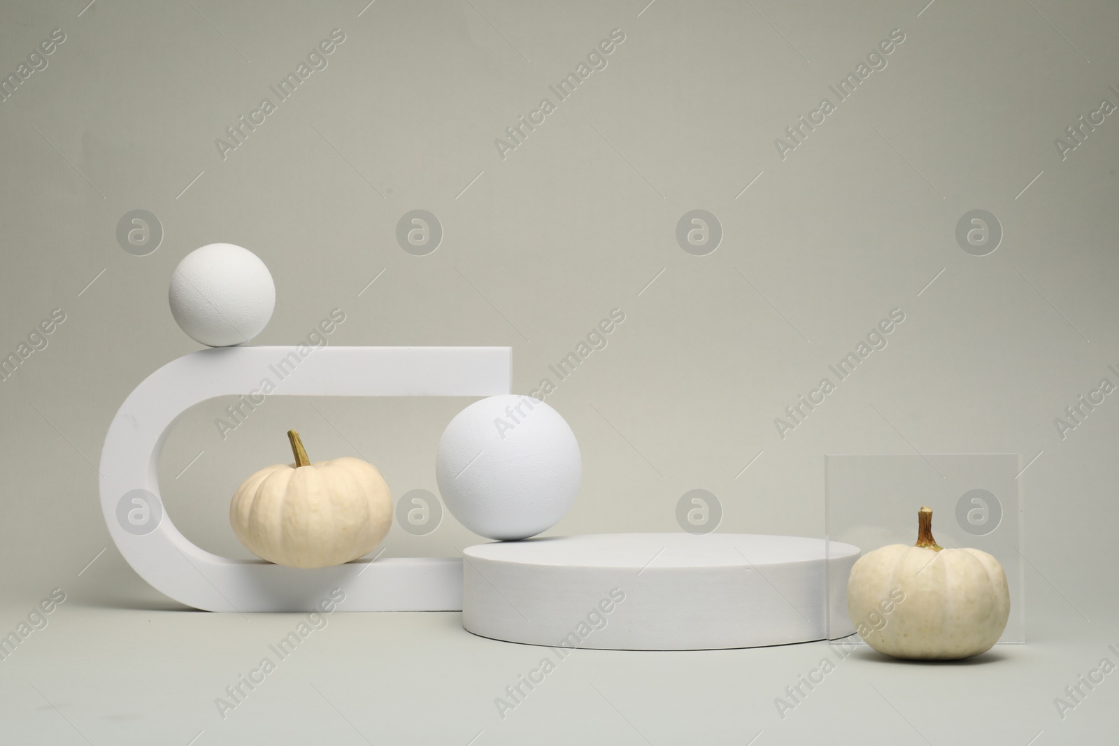 Photo of Autumn presentation for product. Geometric figures and pumpkins on light grey background