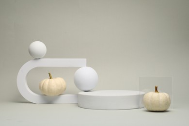 Photo of Autumn presentation for product. Geometric figures and pumpkins on light grey background
