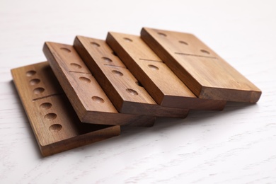 Photo of Fallen wooden domino tiles on white table