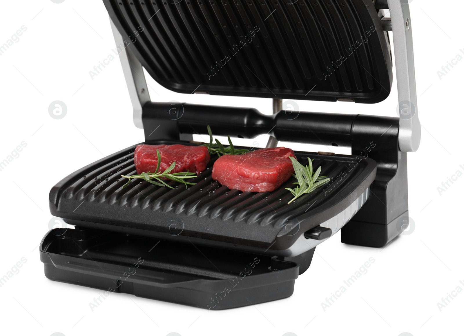 Photo of Electric grill with raw meat steaks and rosemary isolated on white