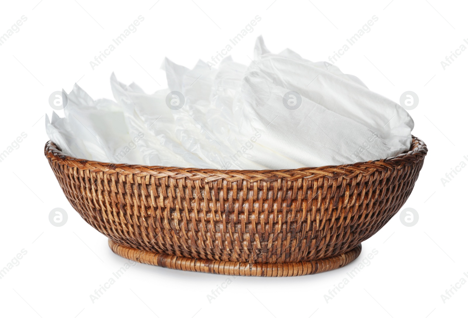 Photo of Wicker bowl with disposable diapers isolated on white