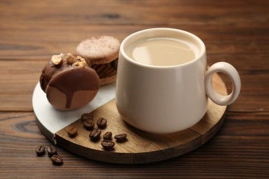 Photo of Cup of coffee and delicious macarons on wooden table