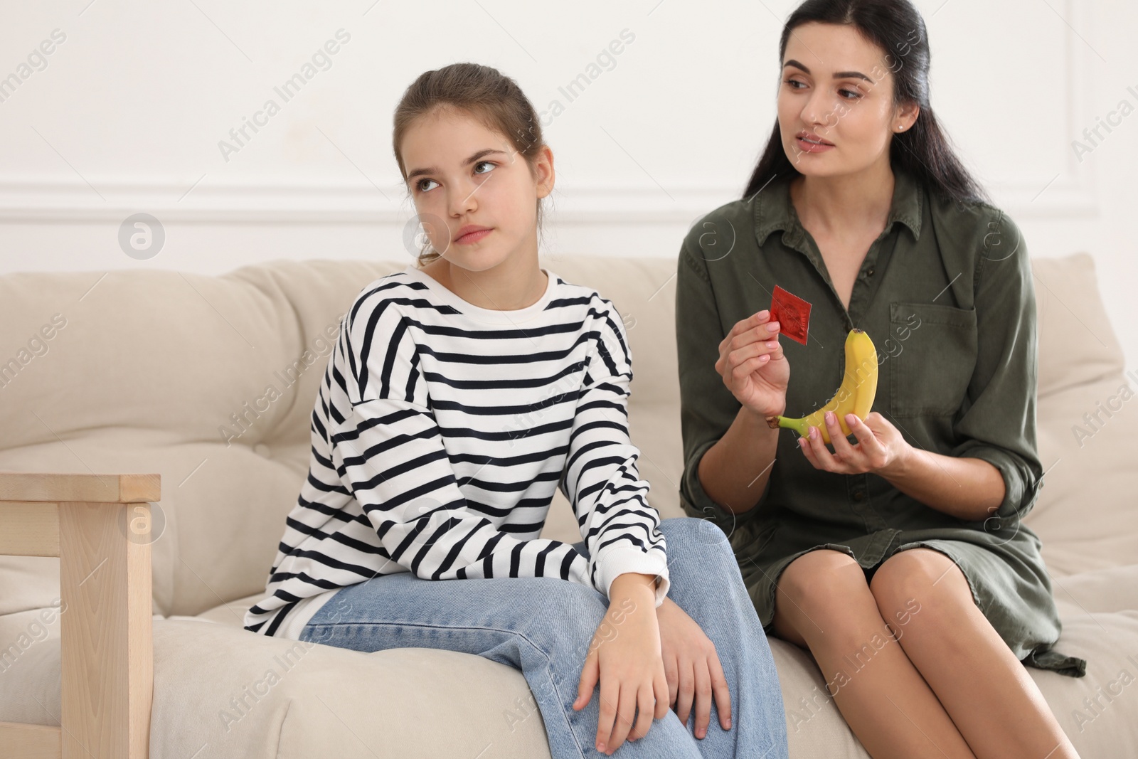 Photo of Mother talking with her teenage daughter about contraception at home. Sex education concept