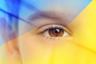 Double exposure of Ukrainian national flag and little boy, closeup view