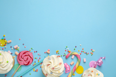 Photo of Flat lay composition with cupcakes on light blue background, space for text. Birthday party